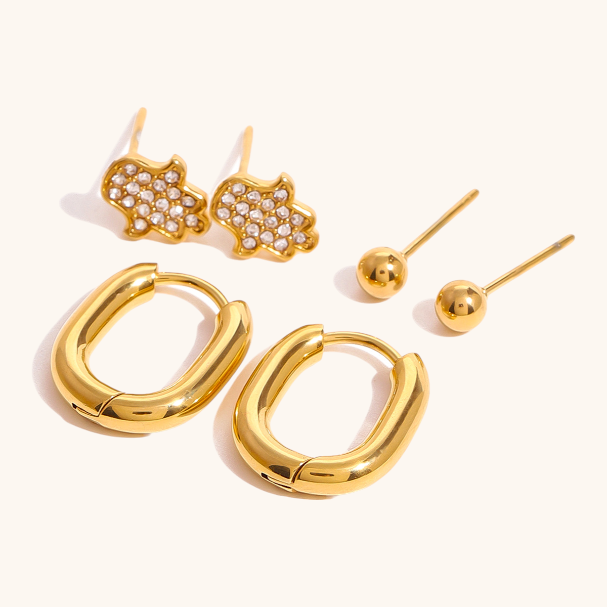 Chunky waterproof gold hoop earrings for daily wear, photographed on textured stone background.