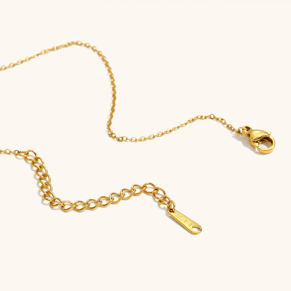 Adjustable gold chain clasp of stainless steel necklace with extension tag.