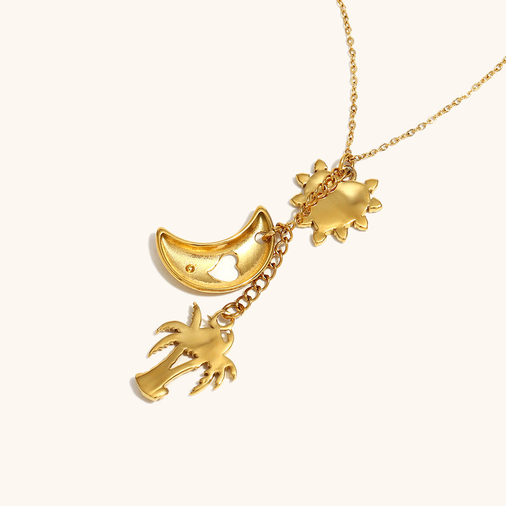 chic gold necklace featuring moon cutout, sunburst heart and tropical palm