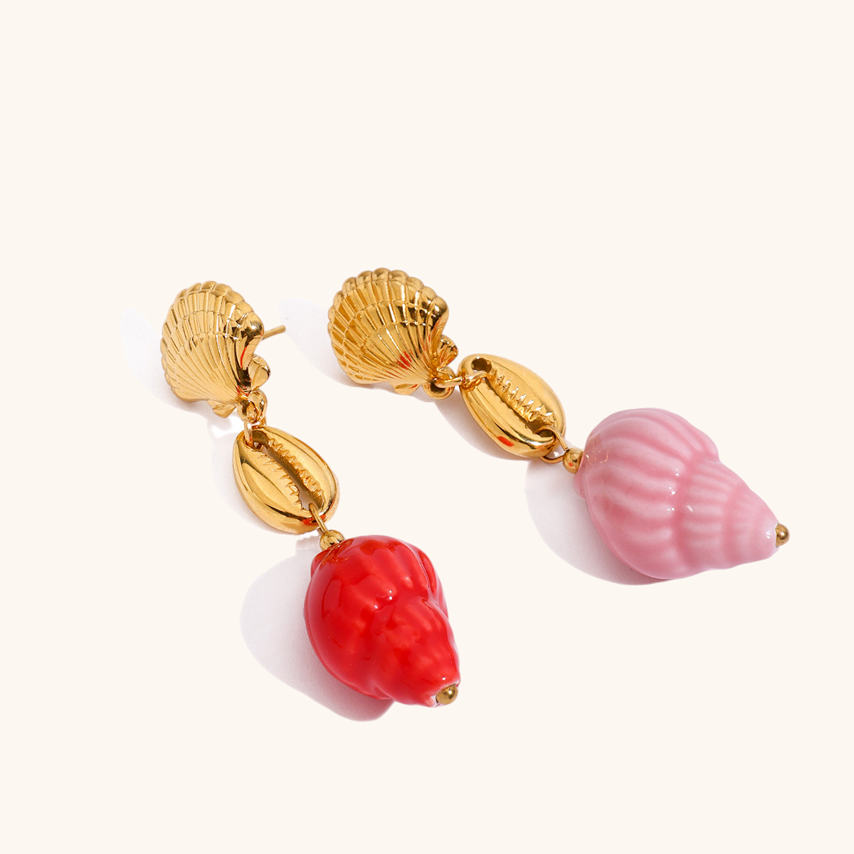 Gold shell earrings featuring pink and red conch drops, styled for tropical summer outfits