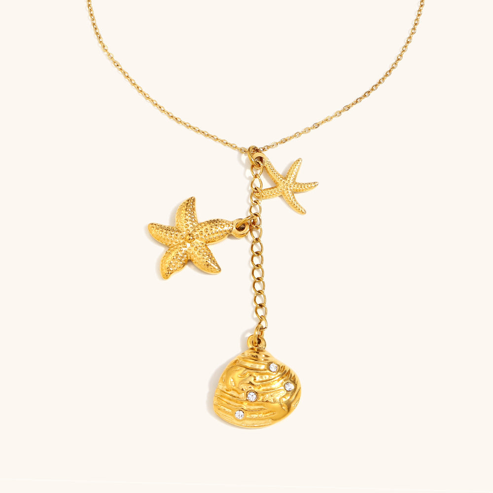 Gold chain necklace with textured starfish and crystal-studded seashell pendant