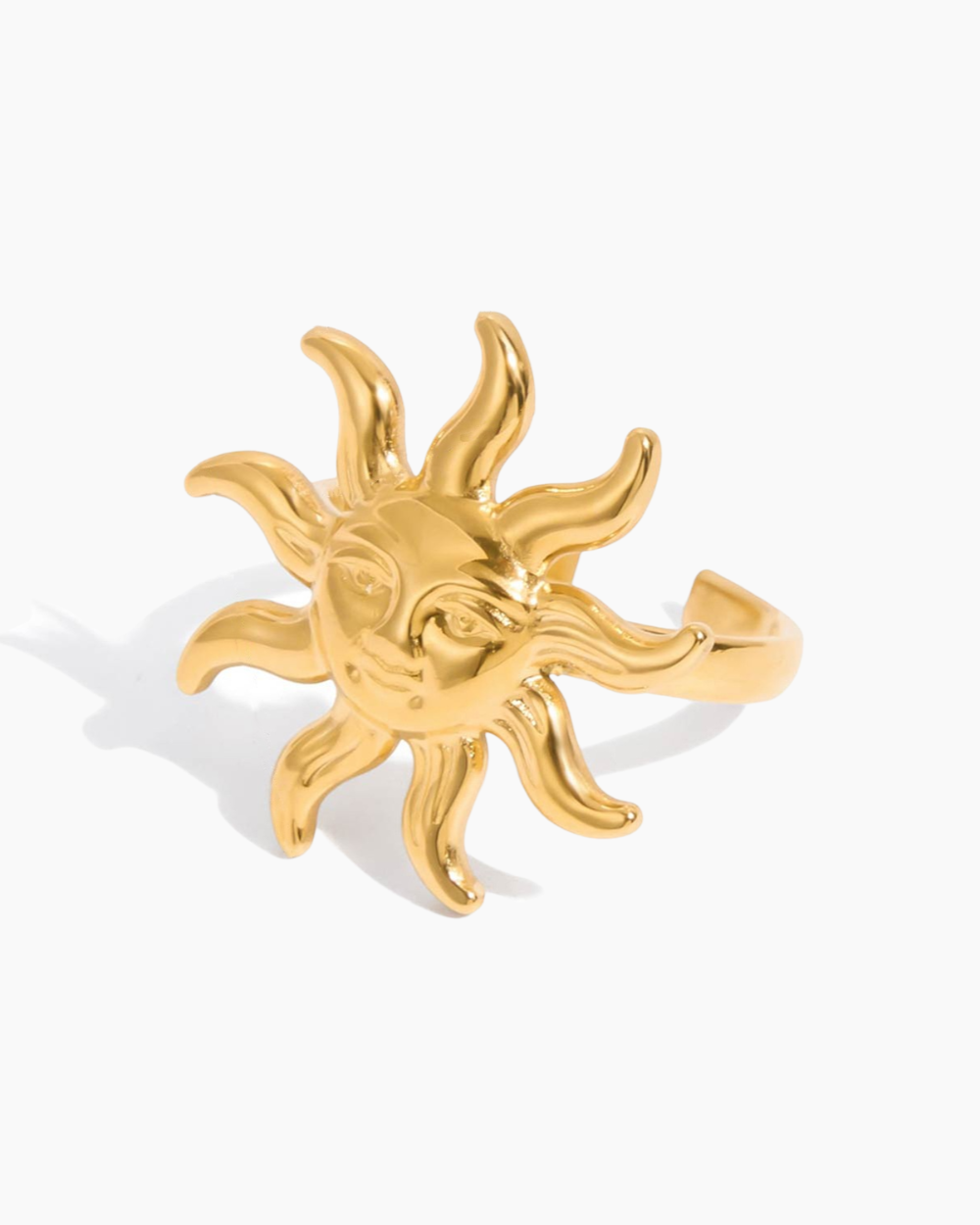 Gold sun-shaped ring on a white background