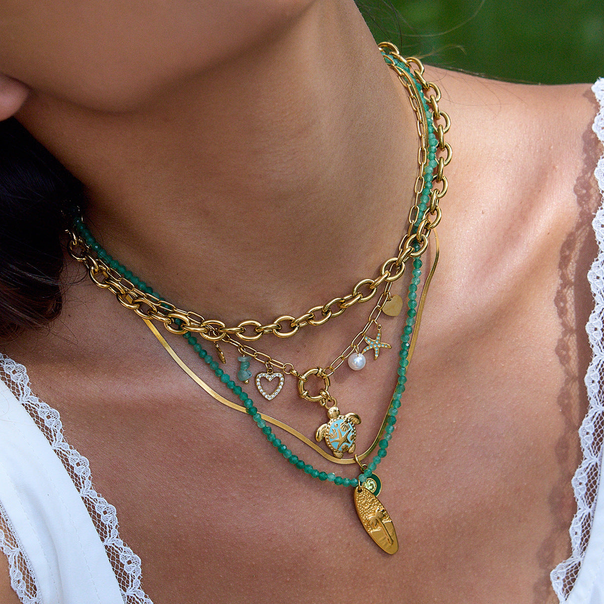 Close-up of model wearing green beaded vacation necklace