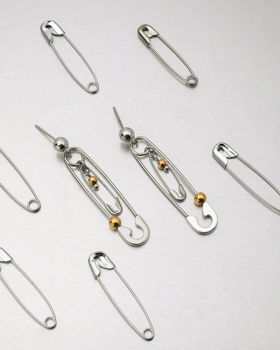 Close-up of silver drop earrings styled with punk-inspired details