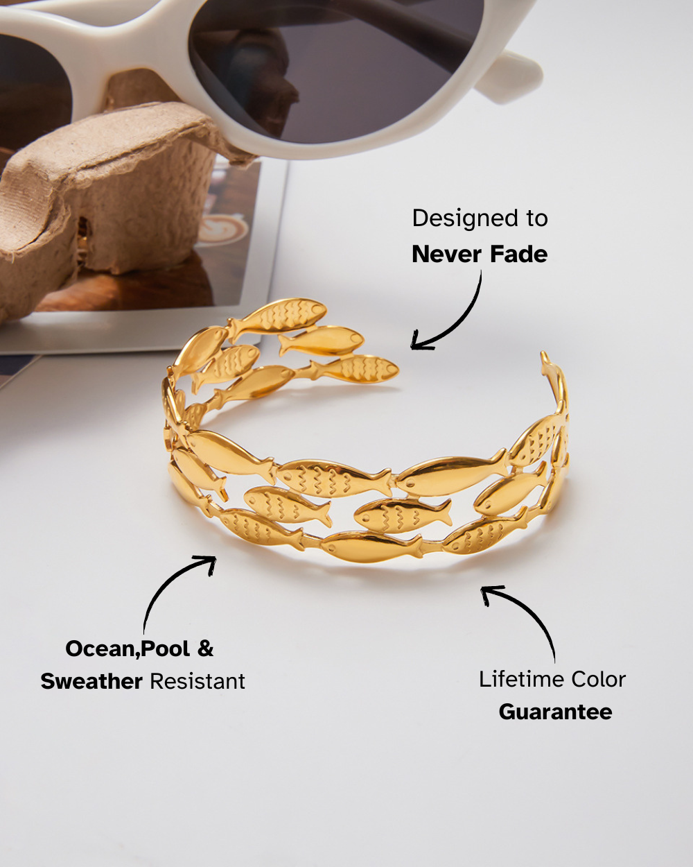 Gold bracelet with leaf design on a white surface, featuring text about durability and color guarantee.