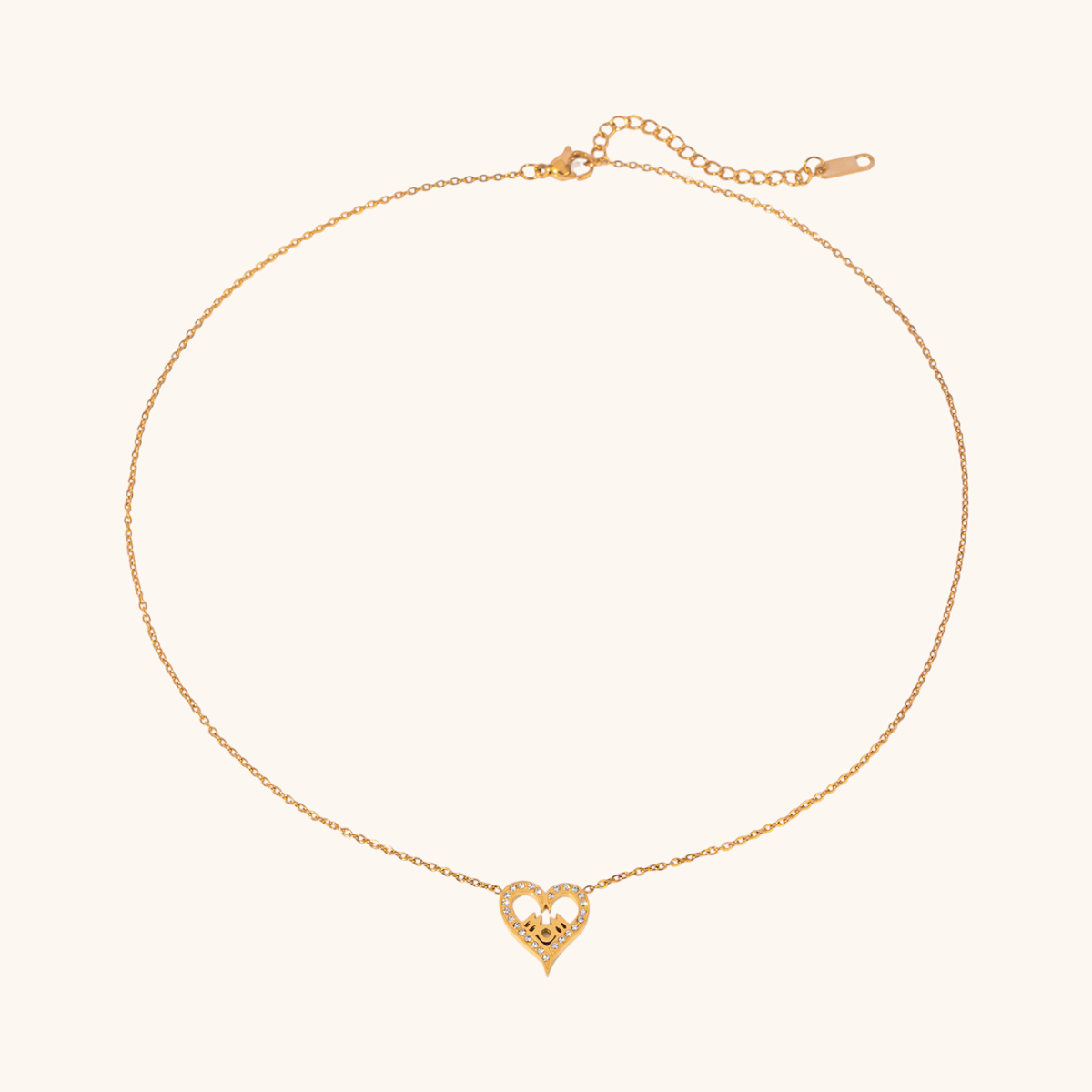 Elegant heart-shaped gold MOM necklace with zircon details, displayed on light beige background