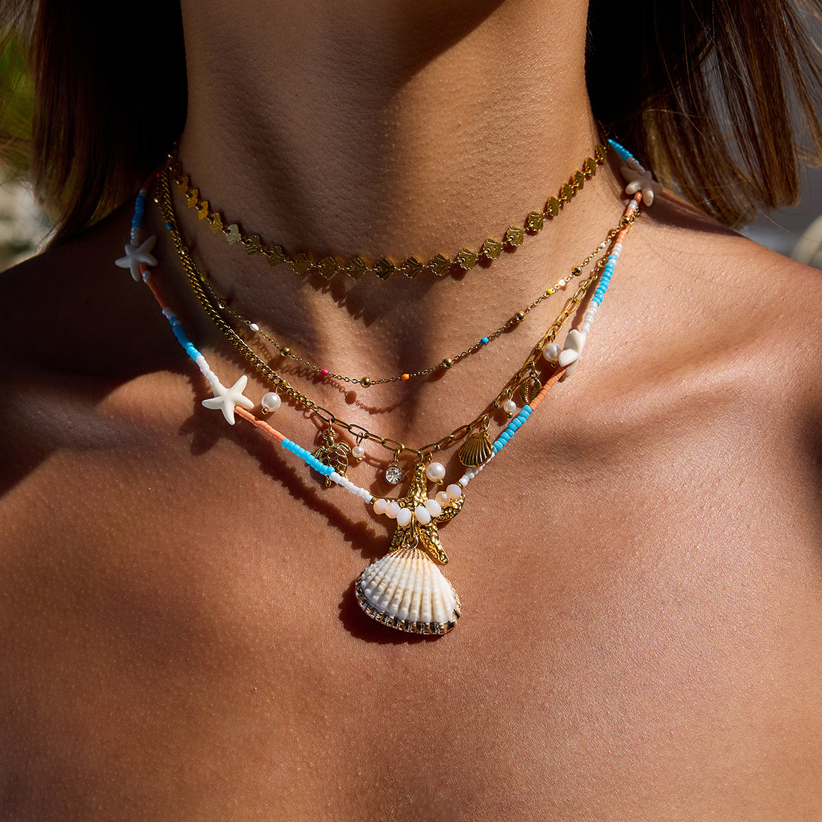 Layered summer necklaces with gold and beaded strands styled on female model