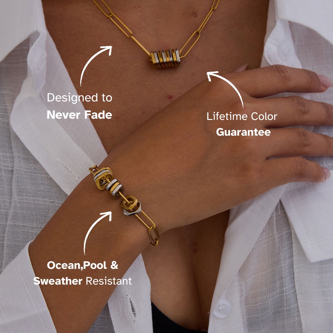 Woman wearing matching bracelet and necklace set with thick gold paperclip chains and metallic disc accents.