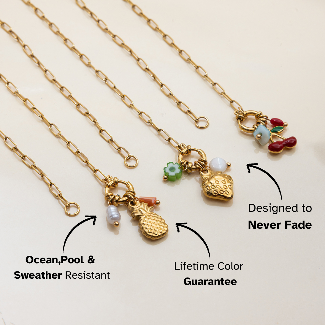 Gold necklaces with various charms on a light beige background