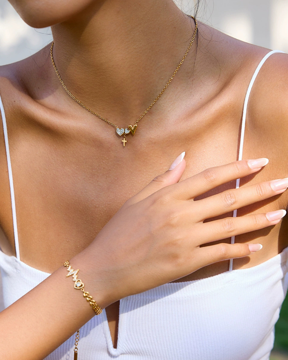 Gold necklace and bracelet on a person with a blurred background