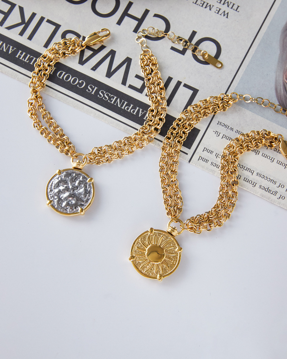 Gold chain necklaces with pendants on a newspaper background