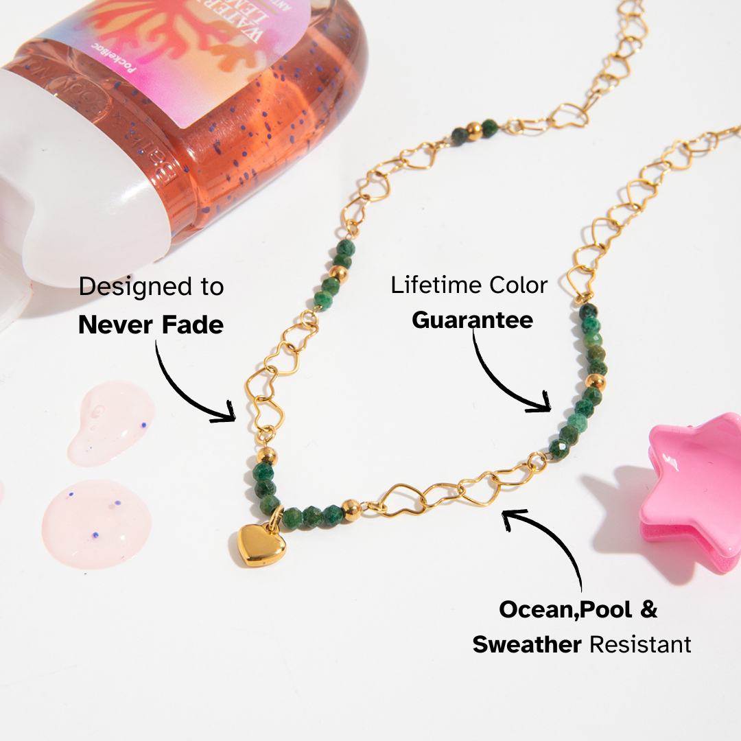 Gold heart charm necklace with green beads styled with colorful candy