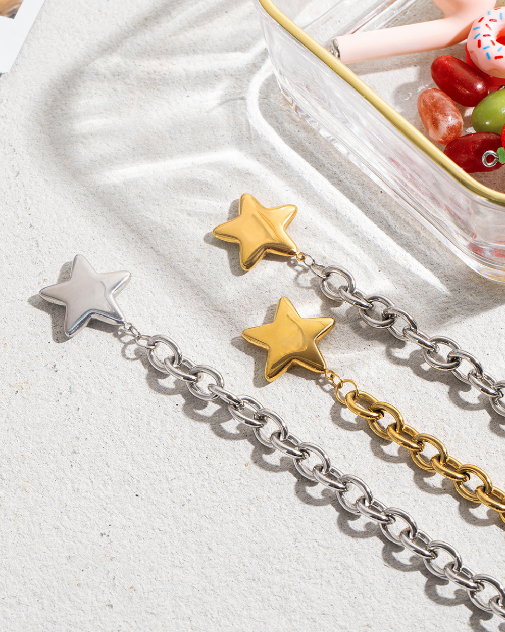 Two chain bracelets with star ends on a light surface.