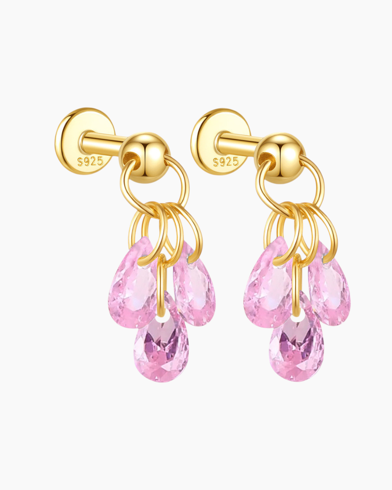 Gold earrings with pink gemstones on a white background