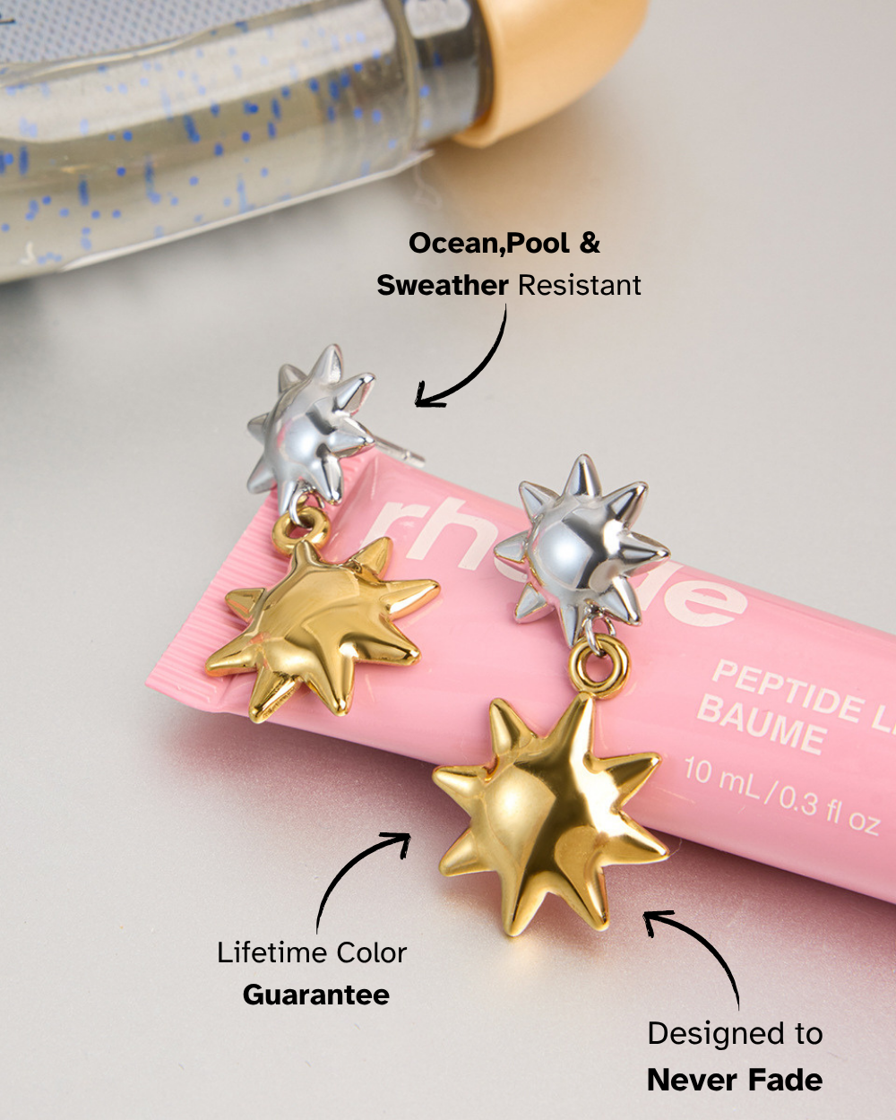 Star-shaped earrings with a bottle of perfume on a light background