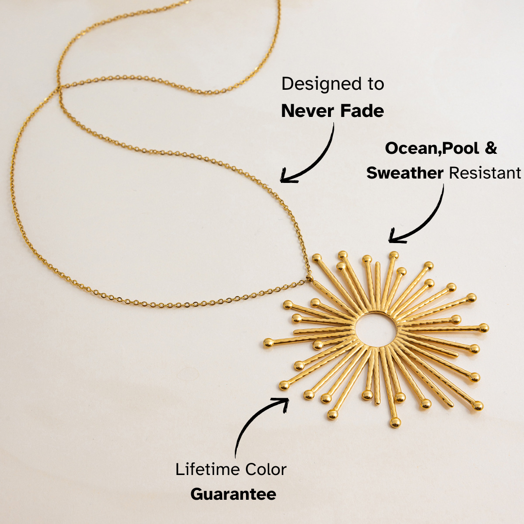 golden sun charm necklace laying flat on light surface