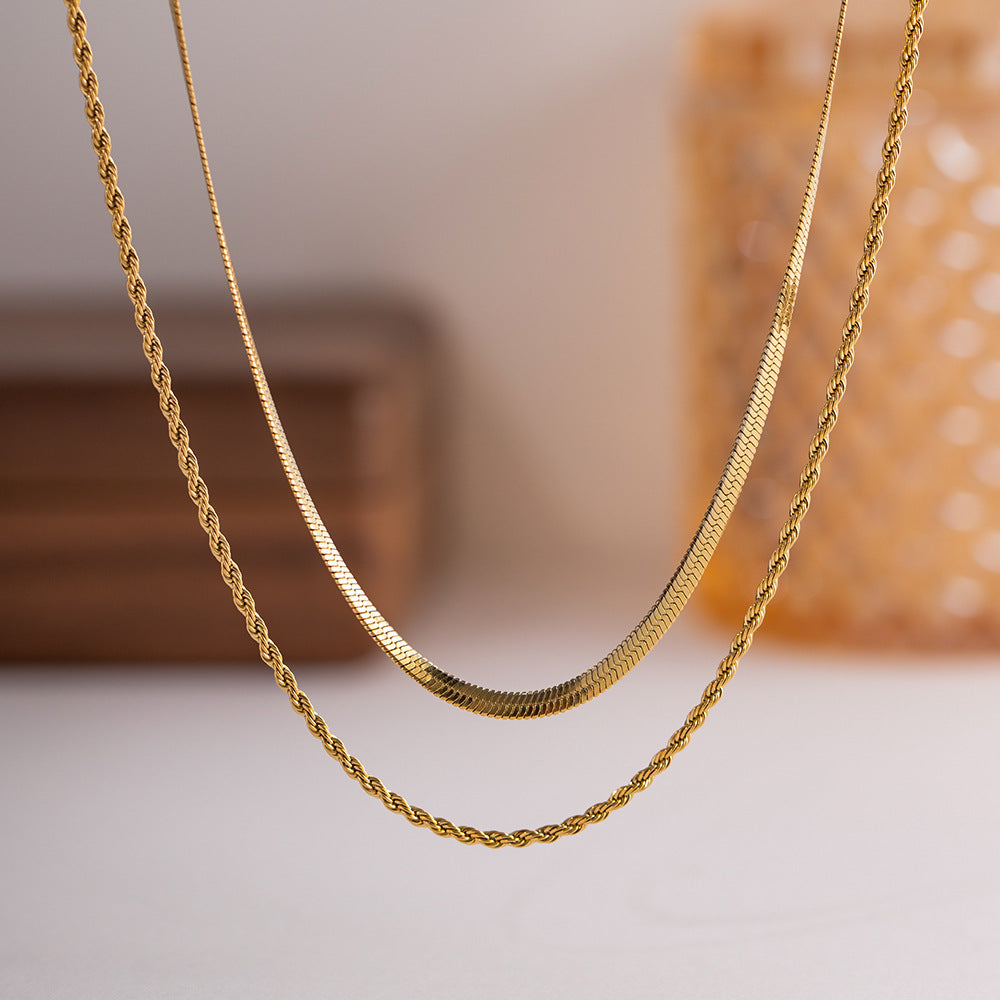 Floating front view of gold rope and snake chain necklace on clean white background