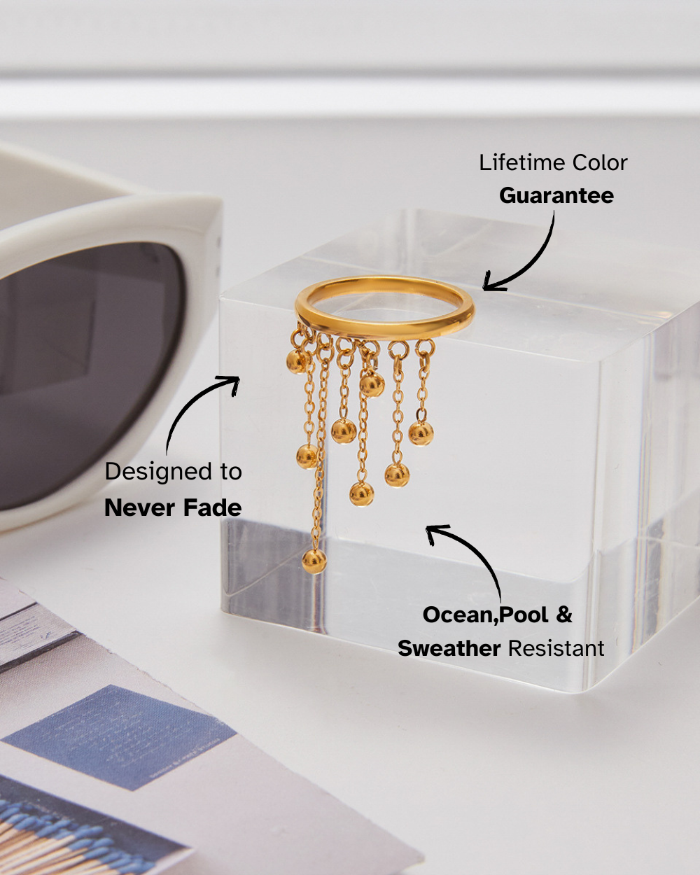 Gold ring with chain design on a clear stand, with text about product features.