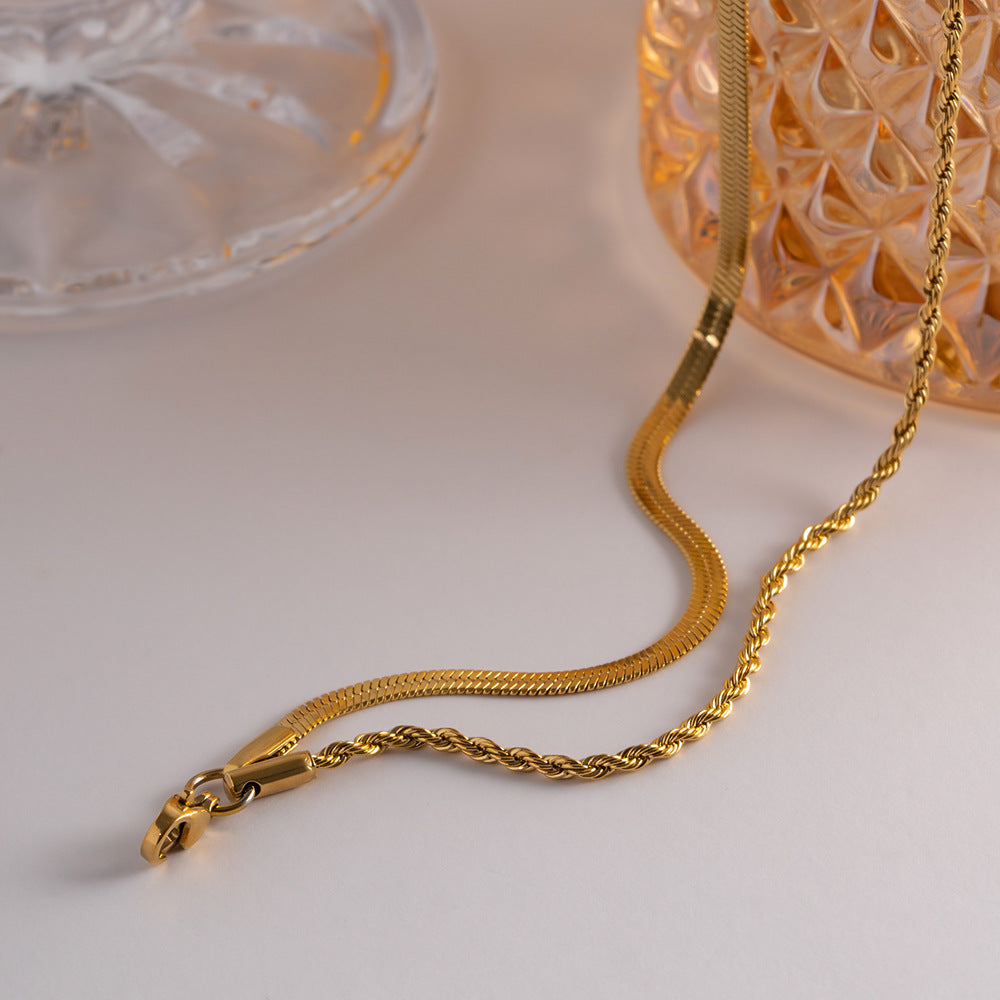 Close-up of the lobster clasp and chain details on a layered gold necklace