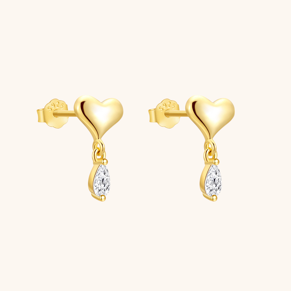 Elegant model with sleek blonde hair wearing minimalist heart-shaped drop earrings
