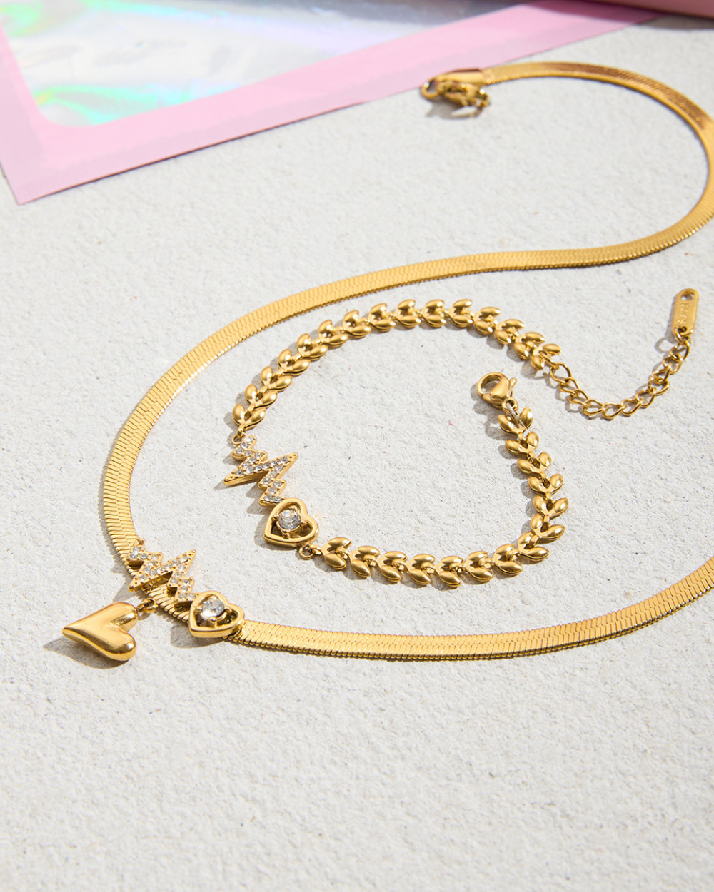 Gold chain necklace with charms on a light gray background