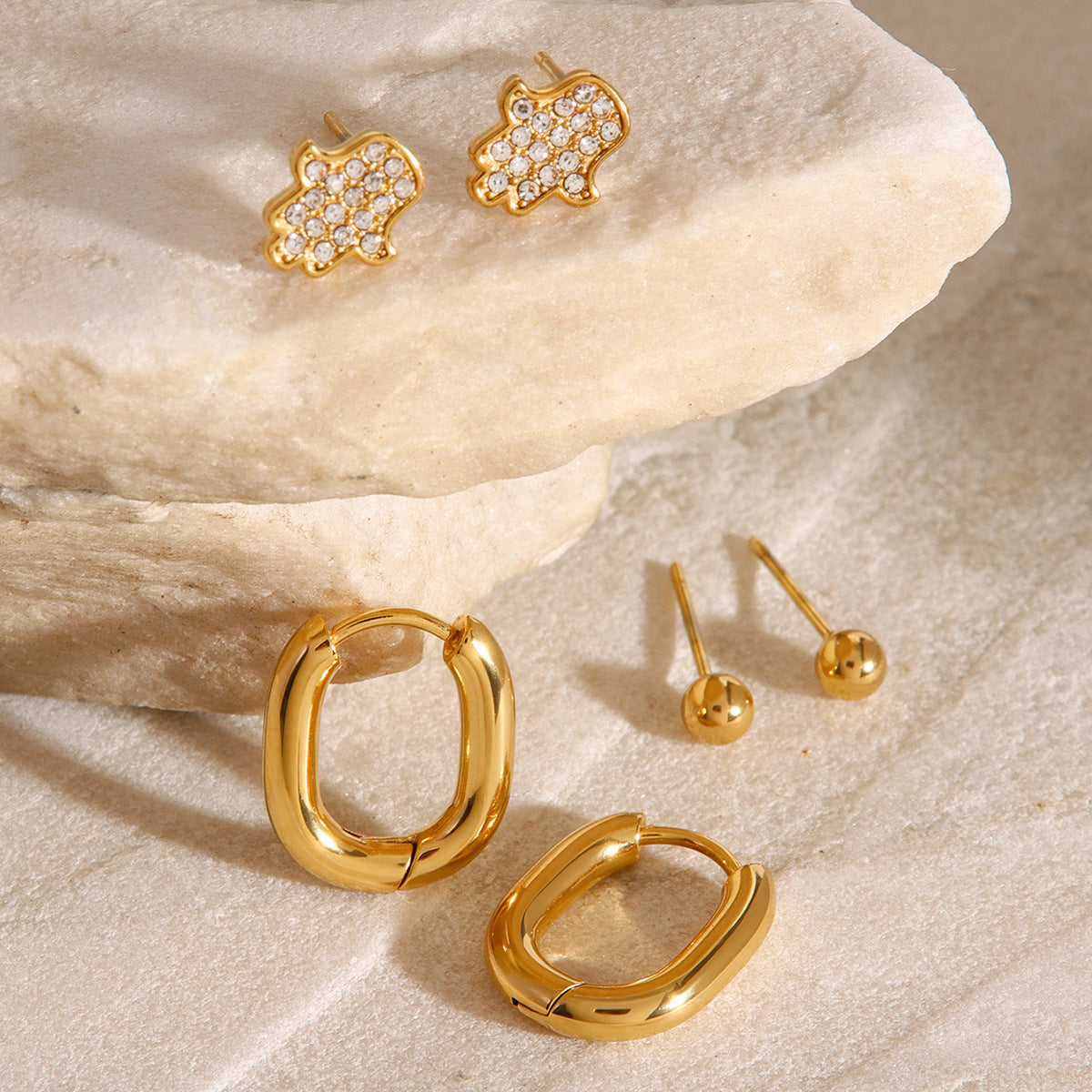 Waterproof gold earring set with hoops, studs, and crystal charms, ideal for multiple piercings.