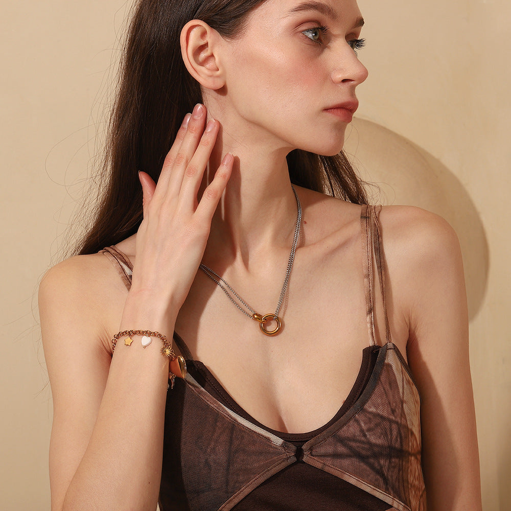 Woman wearing layered necklace with gold hoop pendant