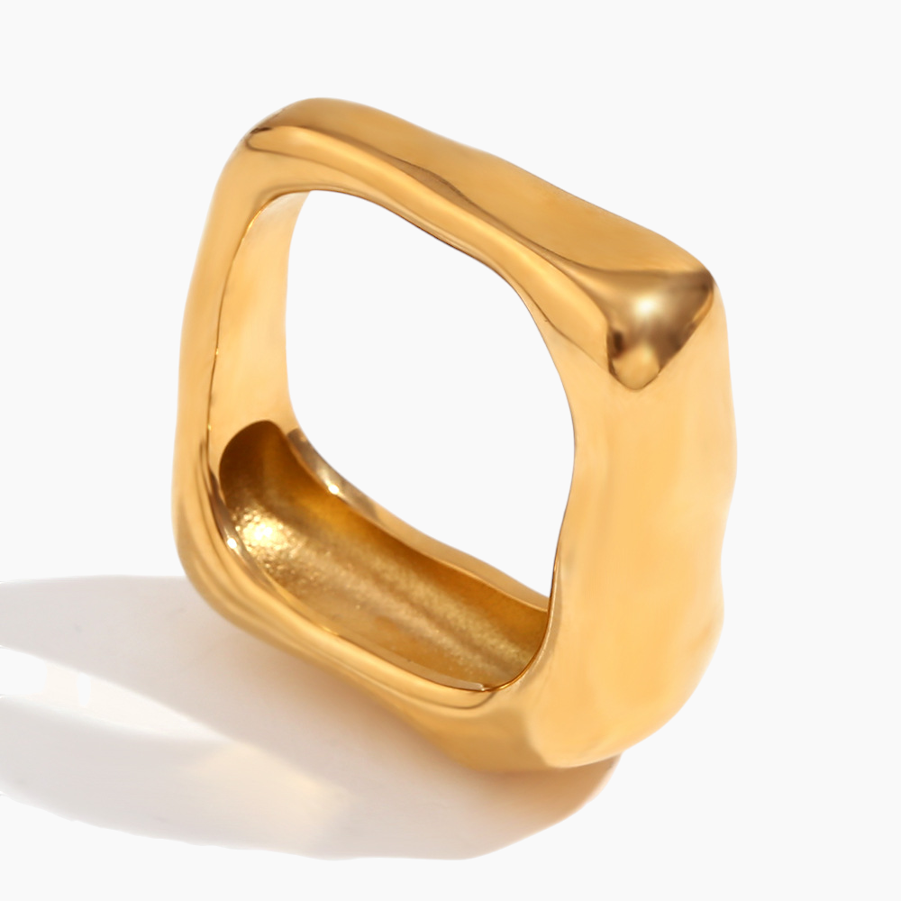 Gold ring with a geometric design on a white background