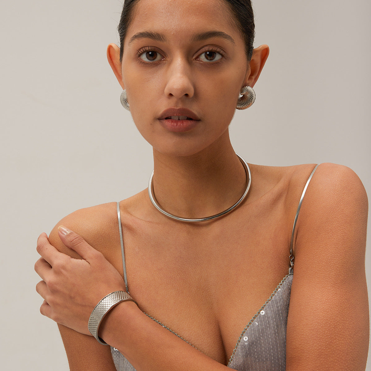 Edgy fashion model in modern gold collar necklace and statement earrings