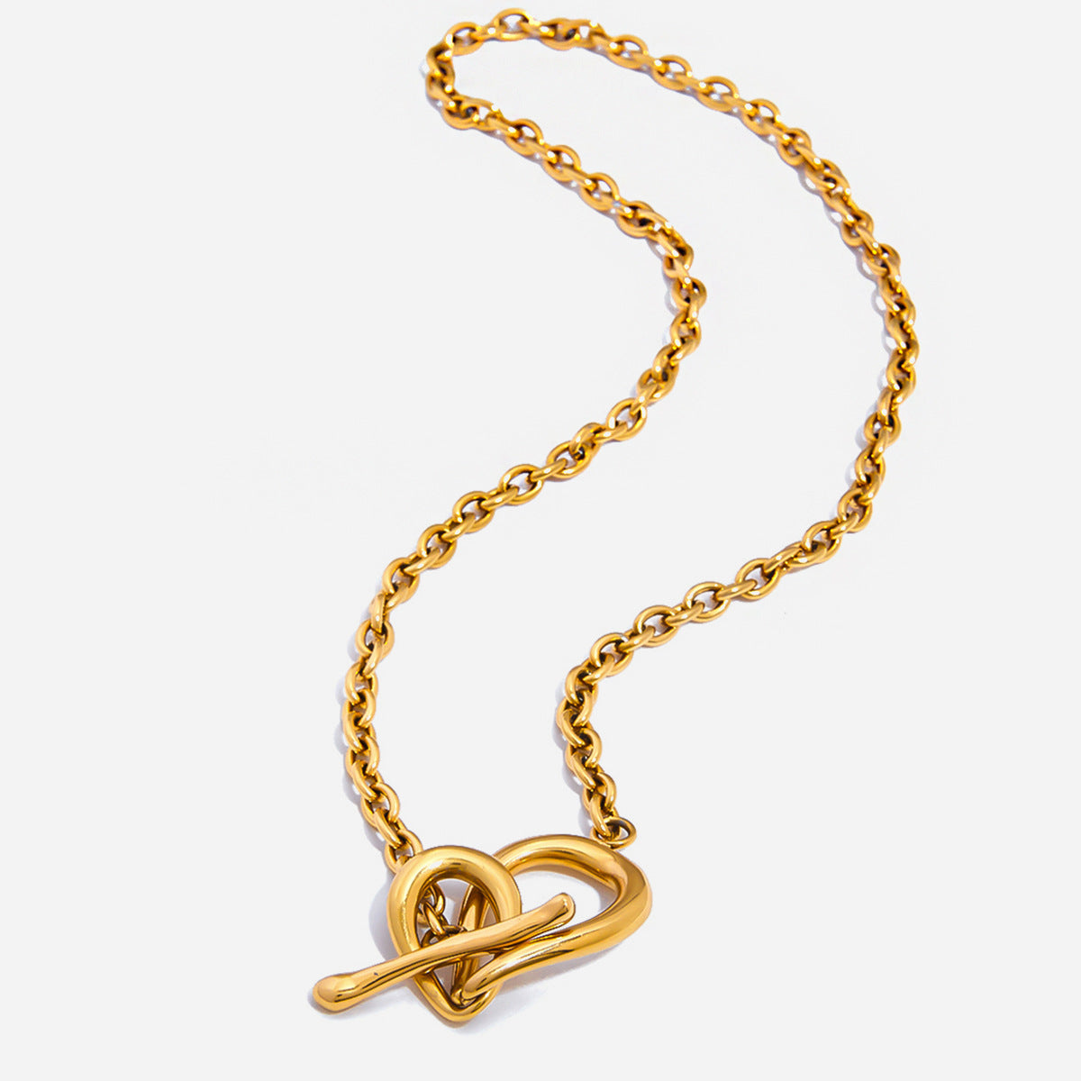 Gold necklace with a heart-shaped pendant on a white background
