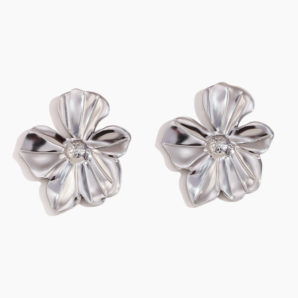 Pair of silver flower-shaped earrings with a central gemstone on a white background