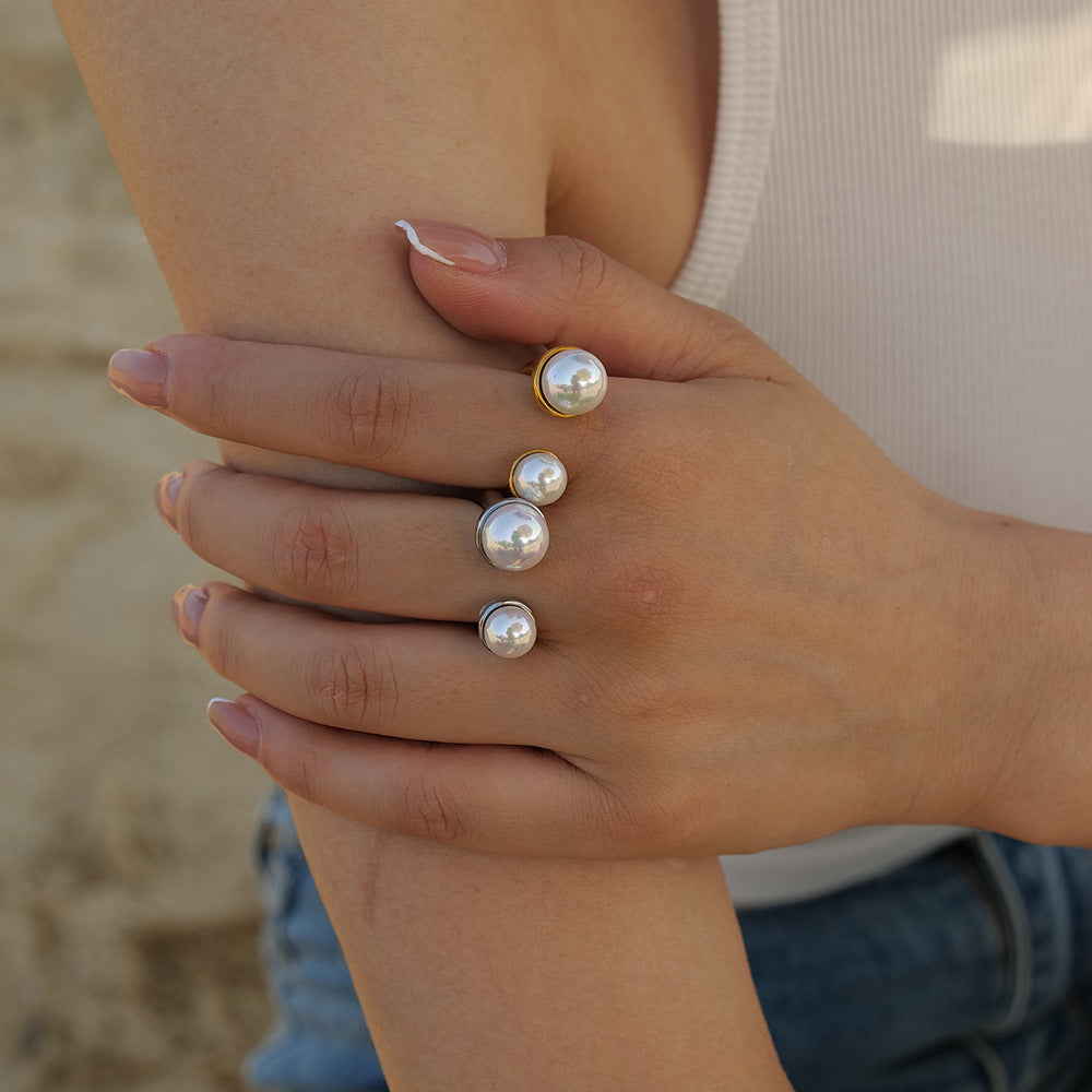 Close-up of double pearl rings worn on hand with neutral nail polish