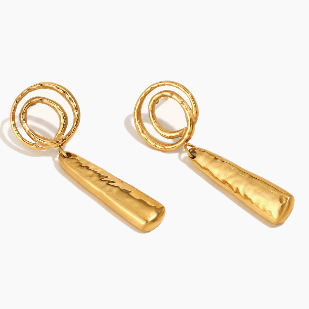 Statement spiral drop earrings paired with layered gold jewelry