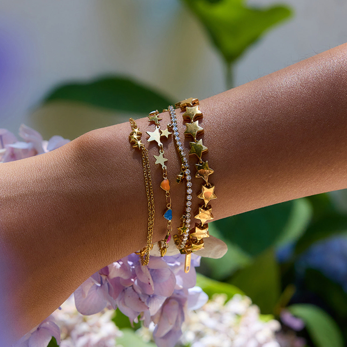 Gold chain bracelet with multicolor heart stones and star details