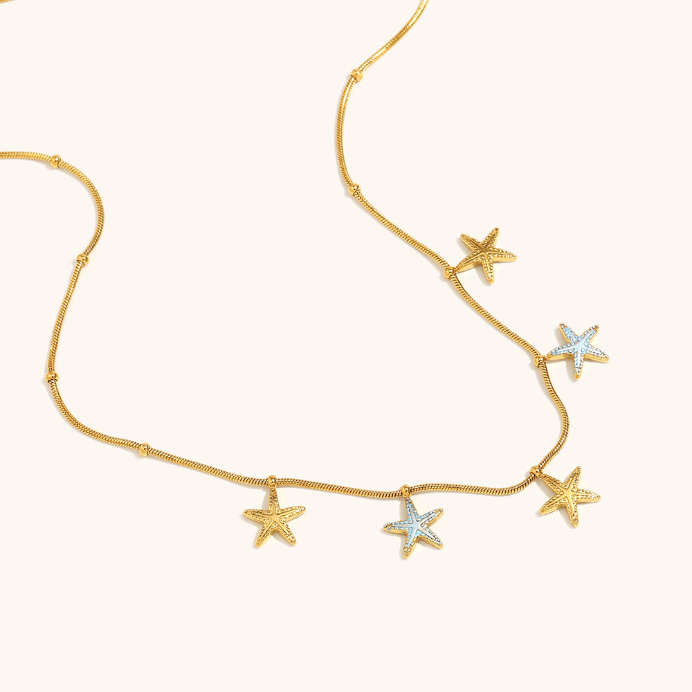 Stylish woman in cream blouse wearing multicolor star necklace