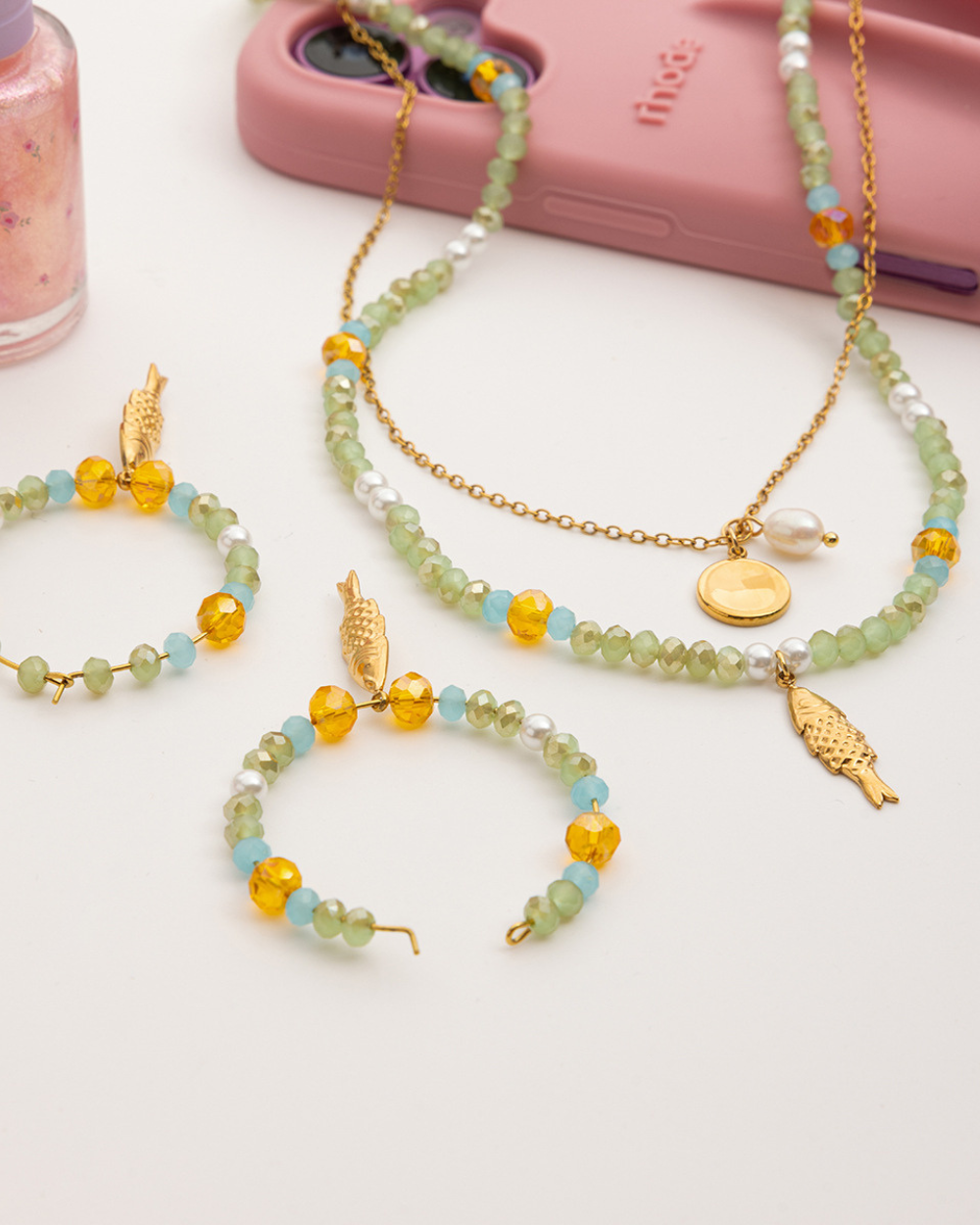 Set of beaded necklaces with charms on a white surface