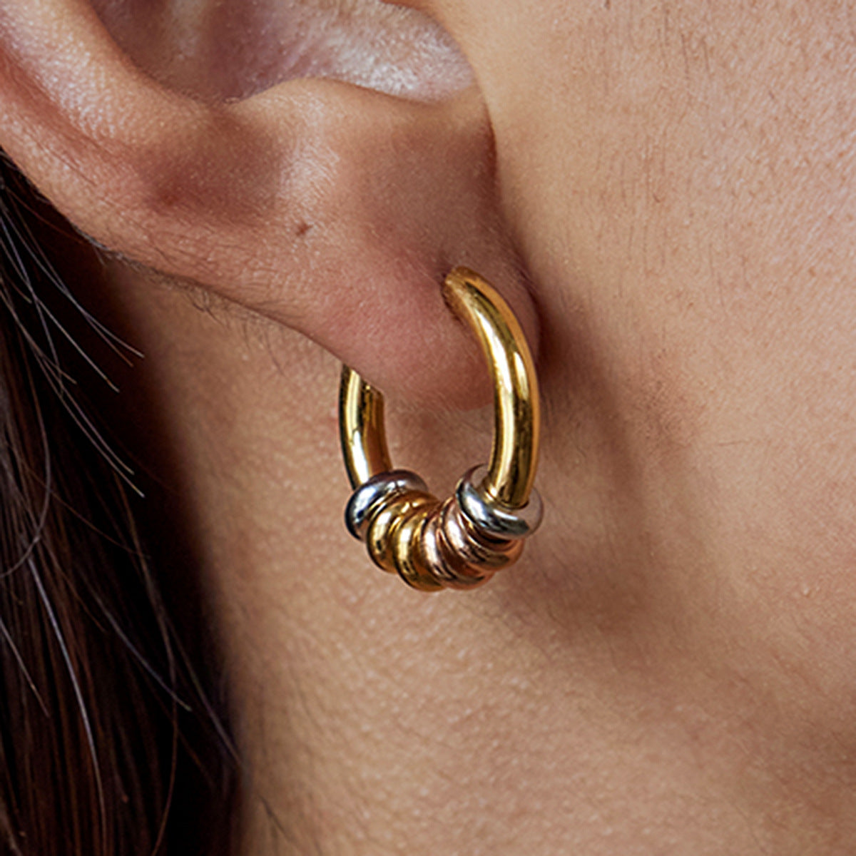 Model wearing chunky beaded hoop earrings