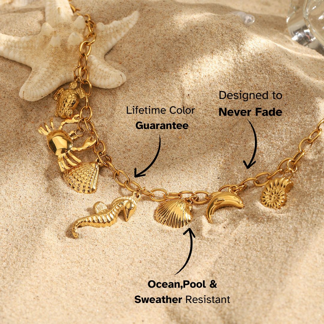 Beach scene with gold charm bracelet featuring marine animals