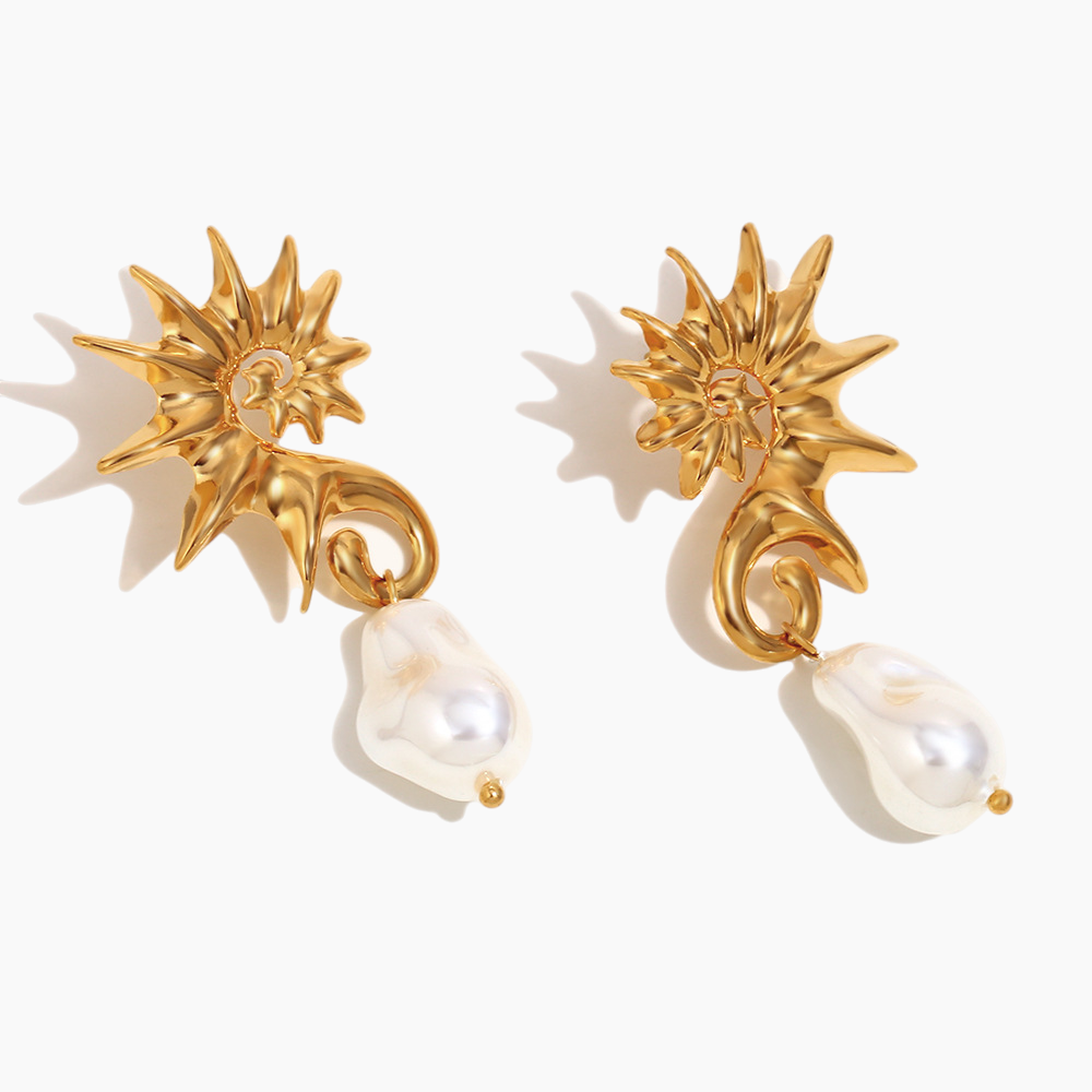 Gold seahorse and pearl drop earrings sparkling in natural light