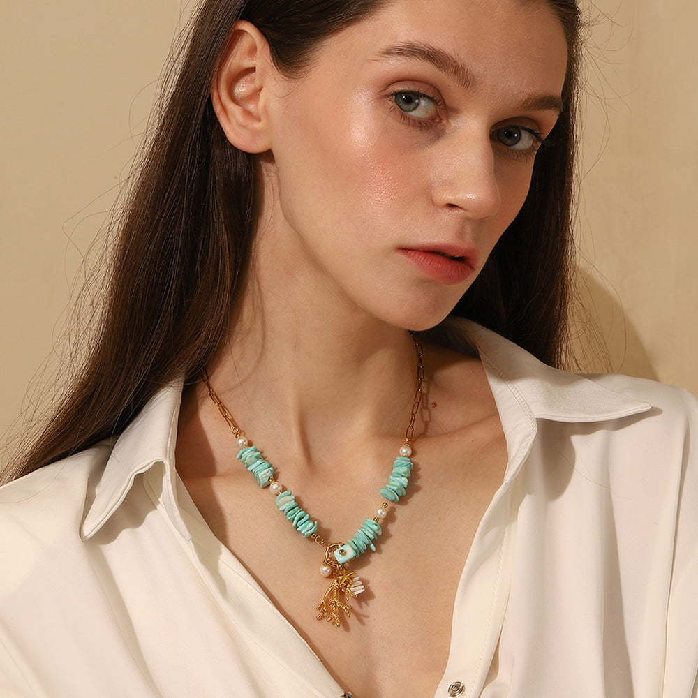 Close-up of layered turquoise chips and sea-inspired charms in gold