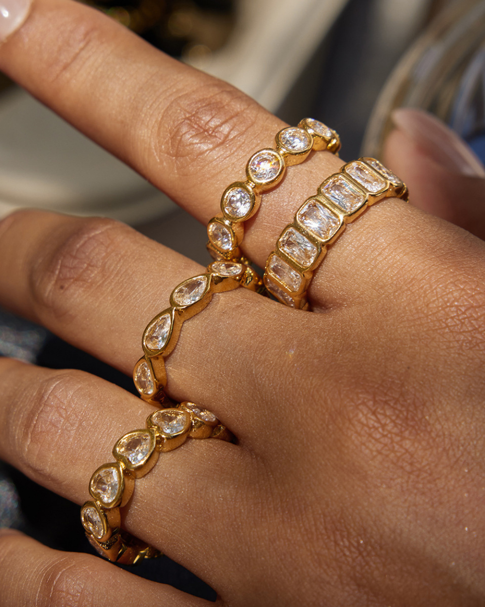 Gold bracelets with clear stones on a person's wrist