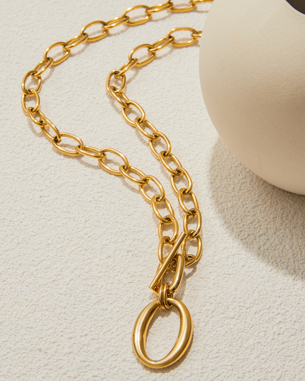 Gold chain necklace on a light beige background