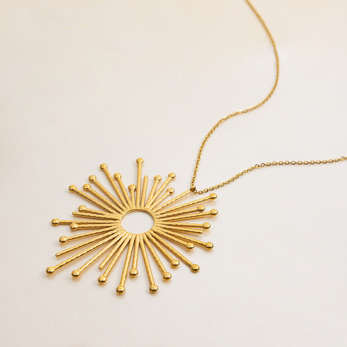 detailed shot of gold rays pendant with round center
