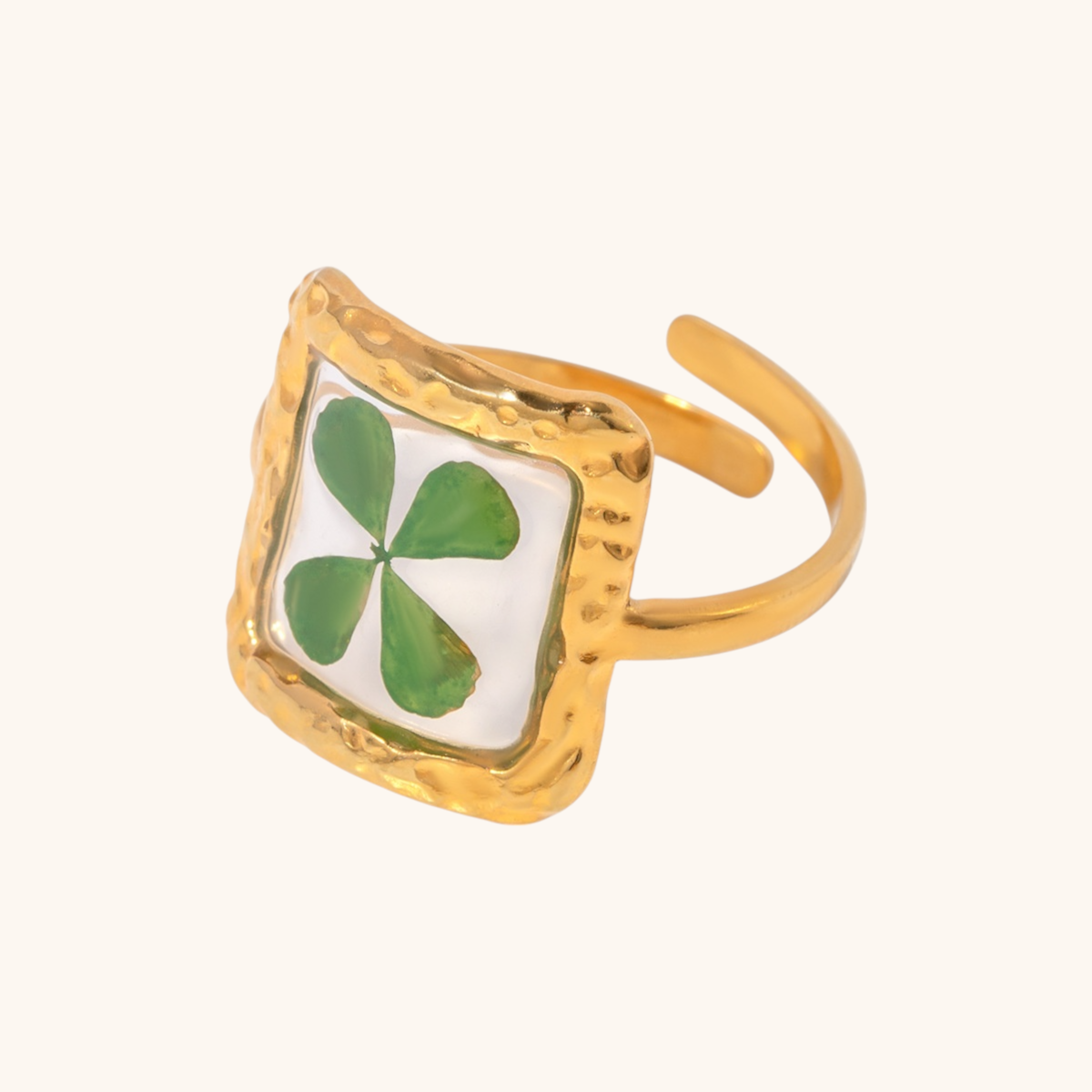 Oval resin ring with light green four-leaf clover design and hammered band