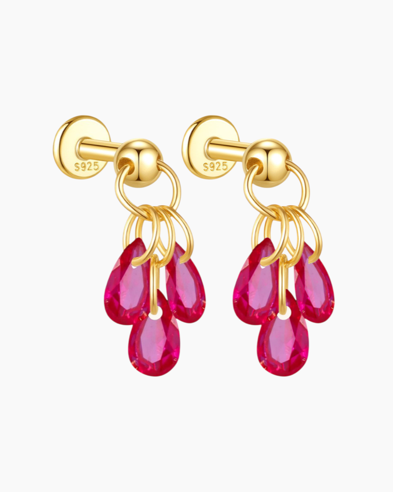 Gold earrings with pink gemstones on a white background