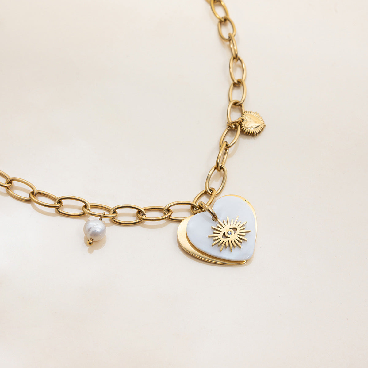 Layered necklaces with sunburst heart pendant and white top
