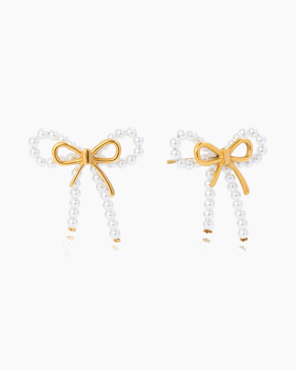 Pair of earrings with gold bow and pearl details on a white background