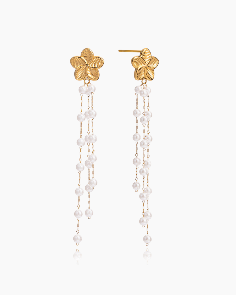 Gold earrings with floral tops and pearl chains on a white background