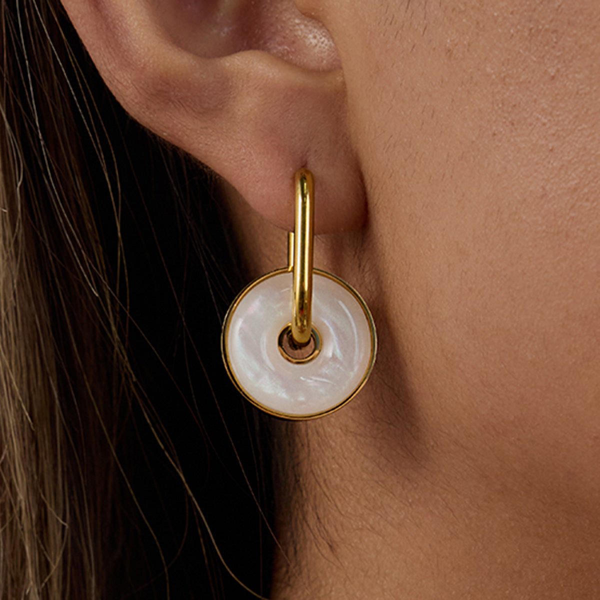 woman wearing pearl donut-shaped drop earrings