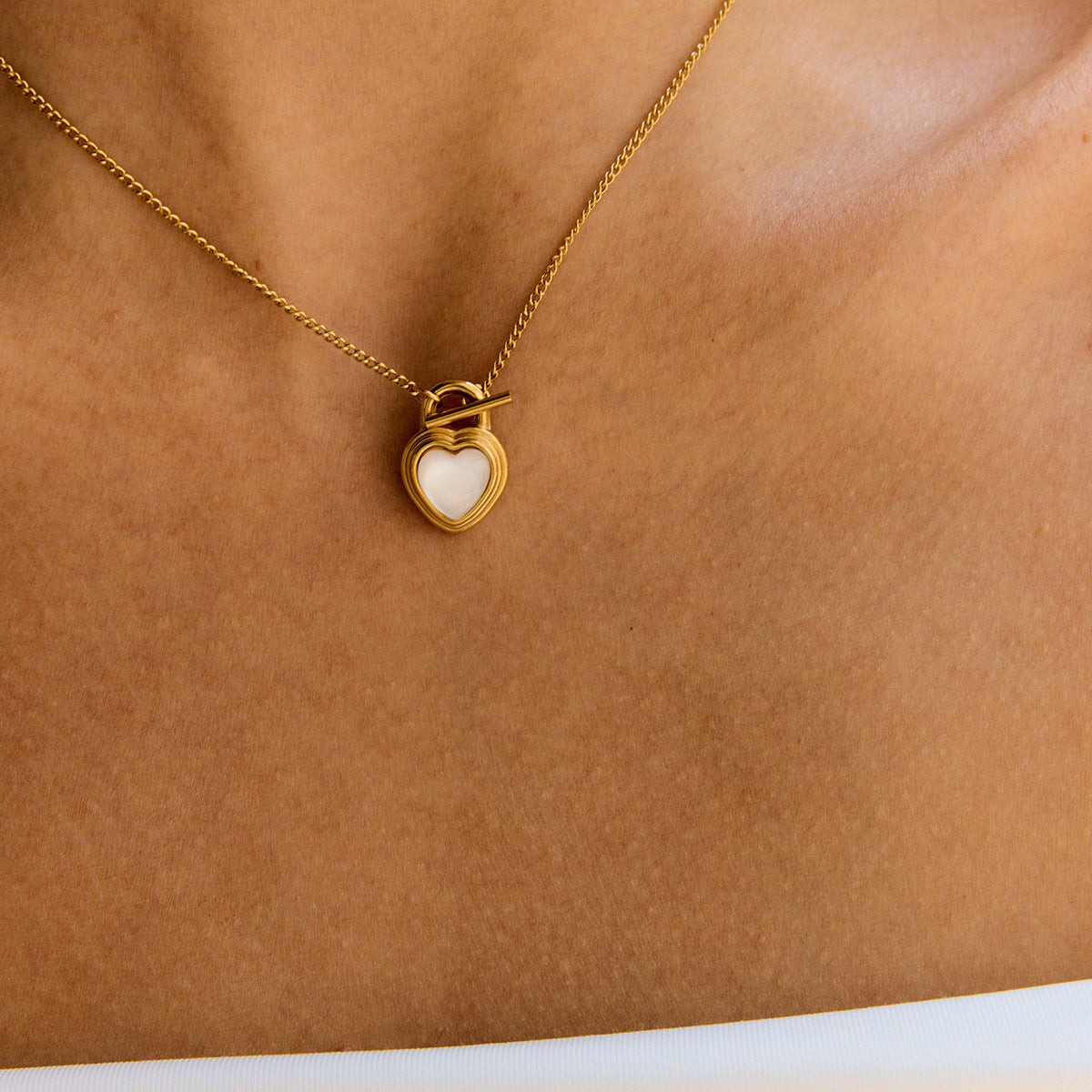 Close-up of pearl heart necklace worn at the collarbone for a summer-ready look